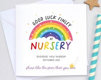 Może przedstawiać: Biała kartka z tęczowym wzorem i napisem "GOOD LUCK FINLEY AT NURSERY". Dodatkowo zawiera "RIVERSIDE VIEW NURSERY SEPTEMBER 2022" i "shine like the star that you are". Karta jest obok białej koperty, drewnianych gwiazdek i słomki w paski.