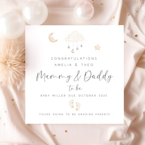 May include: A white card with a gold cloud and stars design. The text reads "Congratulations Amelia & Theo Mummy & Daddy to be Baby Miller Due October 2025 You're going to be amazing parents."