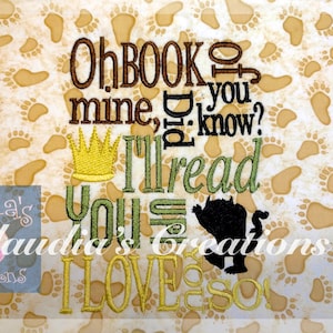 May include: Embroidered design featuring a green and yellow crown, a black silhouette of the monster from the book "Where the Wild Things Are", and the text "Oh BOOK o mine, did you know? I'll read you I LOVE you so!"