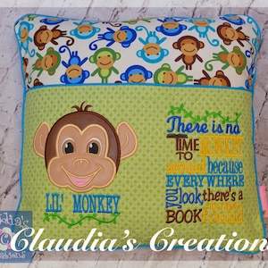 Peut inclure: Un oreiller vert et blanc avec un visage de singe et le texte "Il n'y a pas de temps pour faire le singe car partout où vous regardez, il y a un livre à trouver". L'oreiller a une poche au dos et est décoré d'un motif de singe.