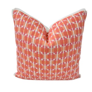 May include: A coral and white patterned throw pillow with a white border.