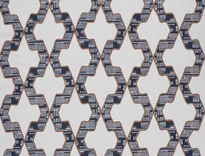 May include: A fabric featuring a repeating geometric lattice pattern in dark navy blue and white. The dark lines are outlined with thin brown stitching and contain small white vertical dashes, creating a structured, interlocking diamond design.