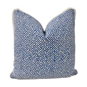 May include: A blue and white patterned throw pillow with a white border. The pattern is a geometric design of interlocking squares.