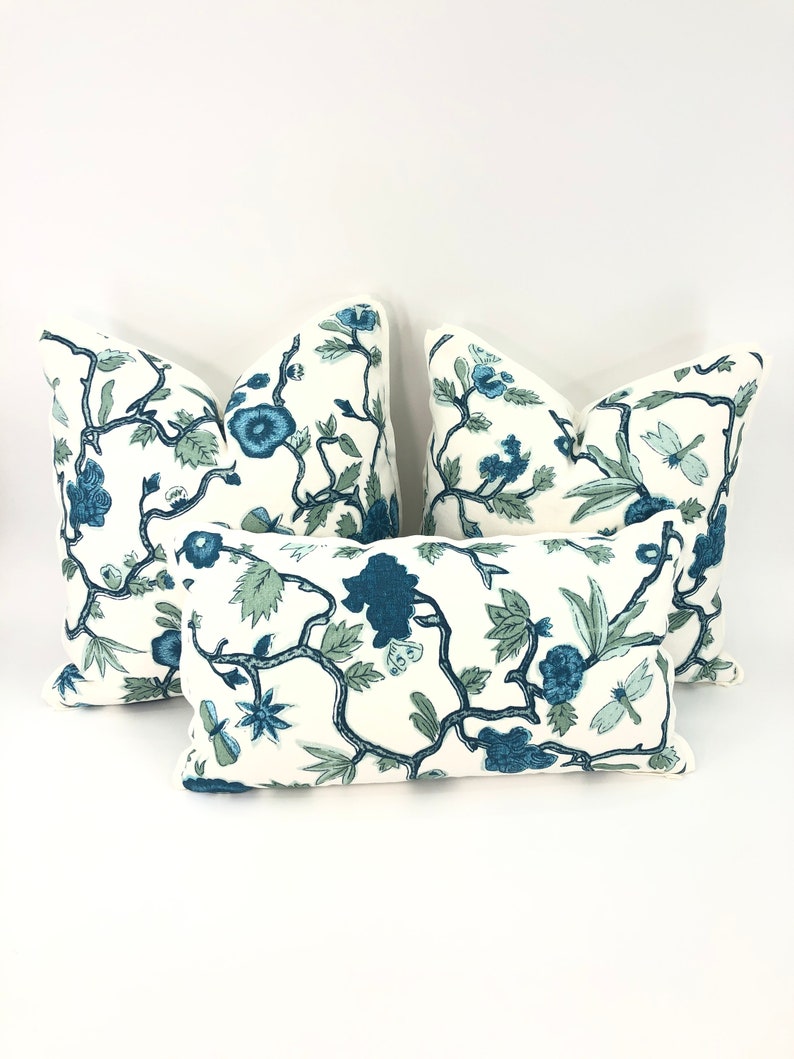May include: Four decorative throw pillows with a white background and a blue floral pattern. The pillows are arranged in a pyramid shape.