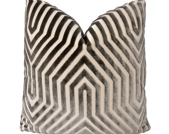 May include: A decorative pillow with a geometric pattern in shades of gray and white. The pillow is made of a soft, plush fabric and has a subtle sheen.