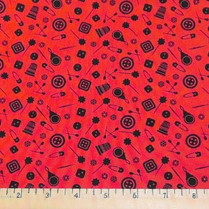 May include: Red fabric with a repeating pattern of black sewing-themed icons, including buttons, needles, thimbles, and safety pins.