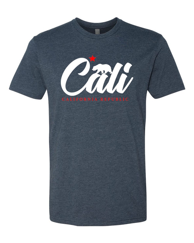 May include: A dark blue t-shirt with a white graphic of the word "Cali" with a red star and a white bear silhouette. The text "CALIFORNIA REPUBLIC" is written in red below the graphic.