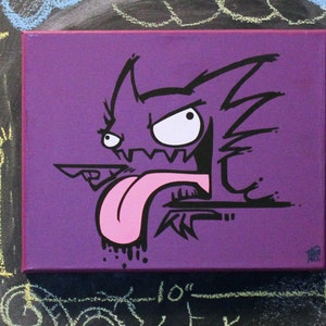 May include: A purple canvas painting with a black and white illustration of a cartoon monster with a pink tongue sticking out. The monster has a large, white eye and a jagged mouth.
