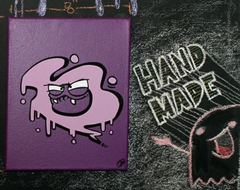 May include: Purple canvas painting with a cartoon character in a pink blob shape with a toothy grin. The background is purple and the text "HAND MADE" is written in white on a black background.