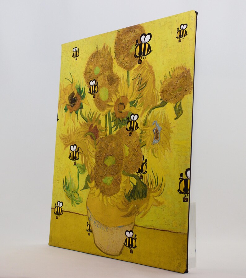 May include: A canvas print of Van Gogh's "Sunflowers" with cartoon bees superimposed on the flowers and background. The artwork features a yellow vase filled with sunflowers against a yellow backdrop, with black and yellow bees scattered across the image.