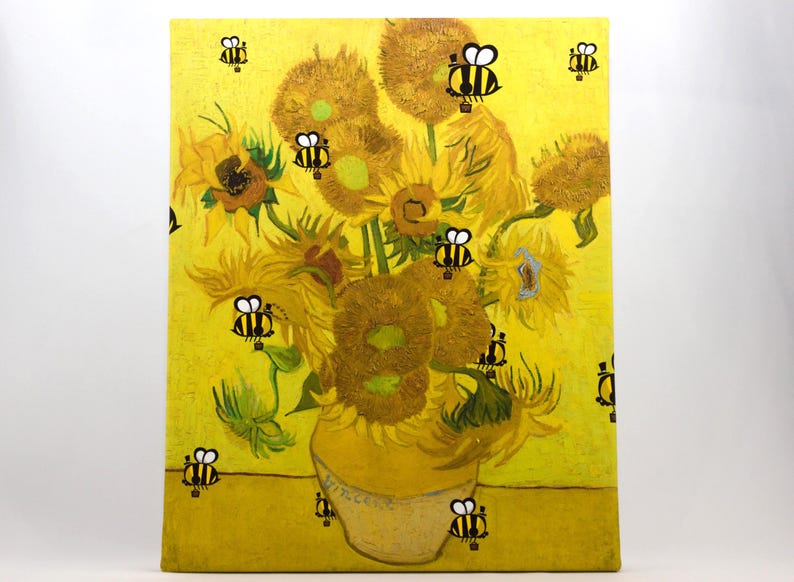 May include: A canvas print of Van Gogh's "Sunflowers" painting, with cartoon bees superimposed on the yellow background. The sunflowers are in a yellow vase, and the bees are black and yellow.