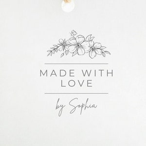 May include: A square white paper tag with a hole at the top and a brown twine string. The tag features a black line drawing of a floral arrangement above the text MADE WITH LOVE and the script name by Sophia, centered on the front surface.