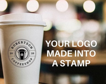 May include: A white disposable coffee cup with a lid, featuring a circular black logo that reads ROBERTSON COFFEESHOP 2020 with a cup icon in the center. To the right, white text reads YOUR LOGO MADE INTO A STAMP against a blurred background.
