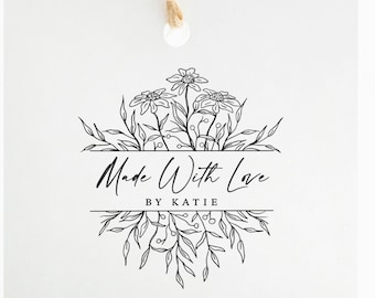 Könnte beinhalten: Ein quadratisches weißes Papieretikett mit einer braunen Schnur an der Oberseite. Das Etikett zeigt eine schwarze Strichzeichnung von Blumen und Blättern, die den Text Made With Love und BY KATIE in einem klaren, professionellen Grafikdesign umgeben.