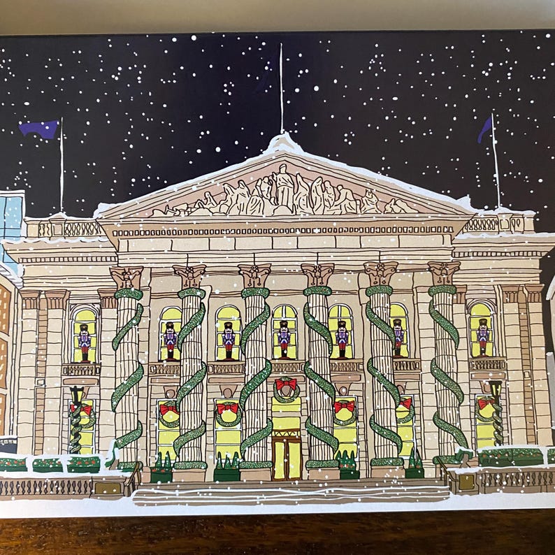 May include: A snowy night scene with a large building decorated with greenery and lights. The building has a classic architectural style with columns and a pediment. There are small figures in the windows that look like nutcrackers.