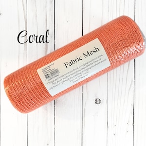 May include: A roll of coral-colored fabric mesh for floral arrangements and decoration. The label reads "Fabric Mesh" and indicates it's waterproof, ideal for fresh or silk flowers, gift baskets, and wrapping. The mesh measures 10 x 10 yards.
