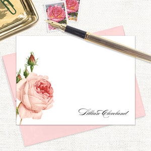 May include: A white card with a pink rose and buds on the left side. The text "Lillian Cleveland" is printed in black cursive on the right side of the card.