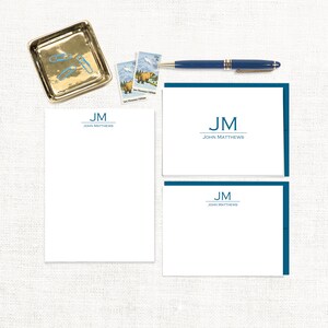 May include: A set of three white stationery note cards with a blue border and the initials "JM" and the name "John Matthews" printed in blue.