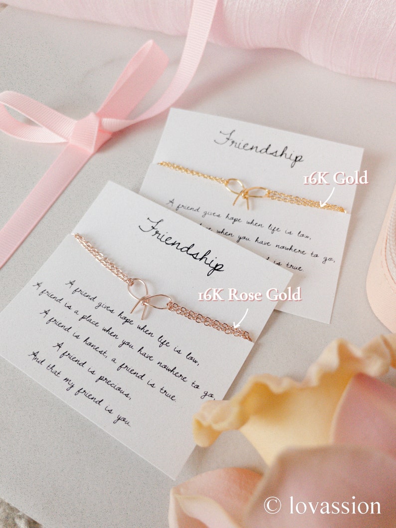 May include: Two cards with the word "Friendship" written on them. The cards are decorated with gold and rose gold chains and the text "16K Gold" and "16K Rose Gold". The cards are surrounded by pink and white flowers.