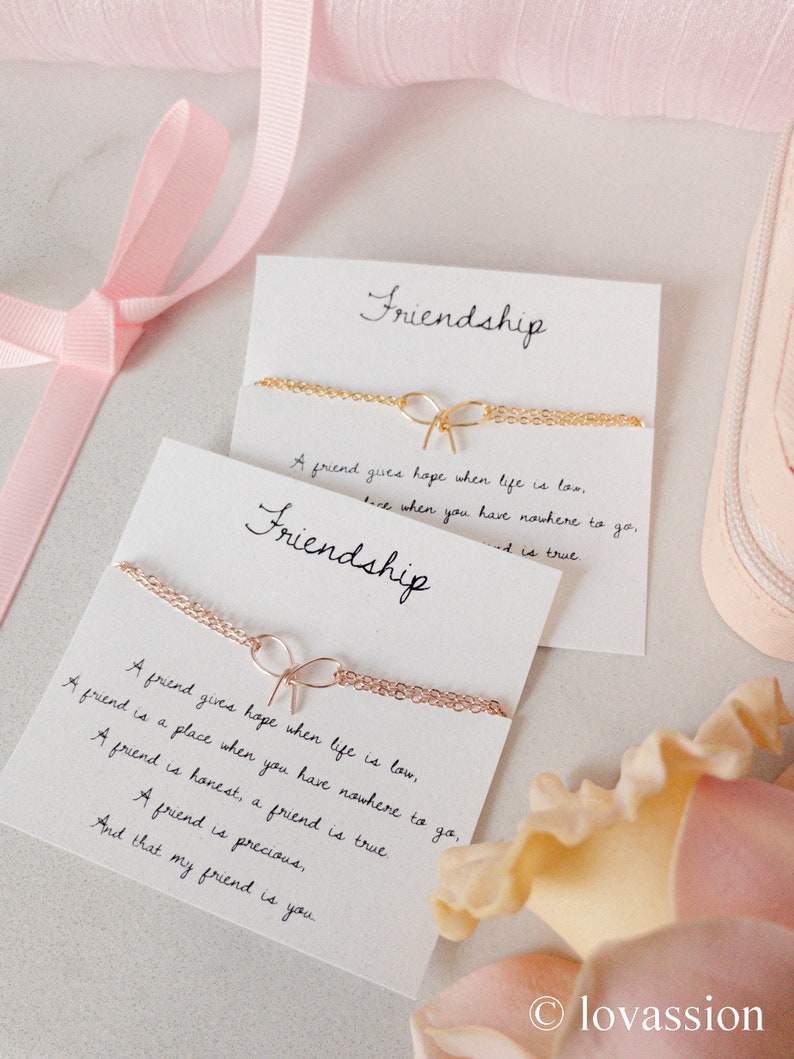 May include: Two cards with the word "Friendship" written on them. The cards are decorated with gold chains and a bow. The text on the cards reads: "A friend gives hope when life is low. A friend is a place when you have nowhere to go. A friend is honest, a friend is true. A friend is precious, And that my friend is you."