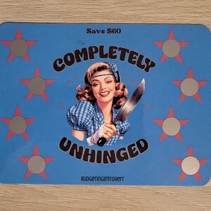 May include: A blue and pink card with a retro-style illustration of a woman holding a knife. The text on the card reads "Save &pound;48 Completely Unhinged Budgetingintrovert".
