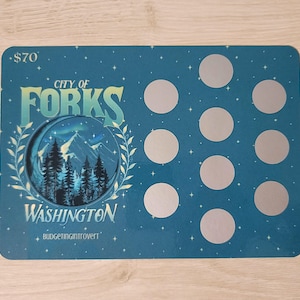 May include: A blue card with the text "City of Forks Washington" and a picture of a forest. The card has a $70 price tag and 10 silver circles.