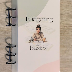 May include: A clear binder with black metal rings. The cover features the words "Budgeting the Basics" with an illustration of a person at a desk. The text "budgetingintrovert" is at the bottom.