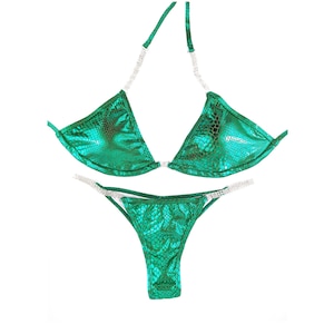 May include: A green bikini with a snakeskin pattern and rhinestones. The top is a triangle style and the bottom is a cheeky cut.