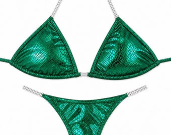May include: A metallic emerald green bikini set with a snakeskin texture. The triangle top and bottom feature thin straps adorned with clear rhinestones. The top has a central rhinestone connector, and the bottom is a high-cut style.