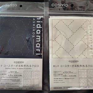 K&ouml;nnte beinhalten: Zwei Packungen Sashiko-Stoff zur Herstellung von Untersetzern. Eine Packung ist schwarz mit einem geometrischen Muster, die andere wei&szlig; mit einem &auml;hnlichen Design. Jede Packung ist ca. 10 x 10 cm gro&szlig; und enth&auml;lt Anweisungen.
