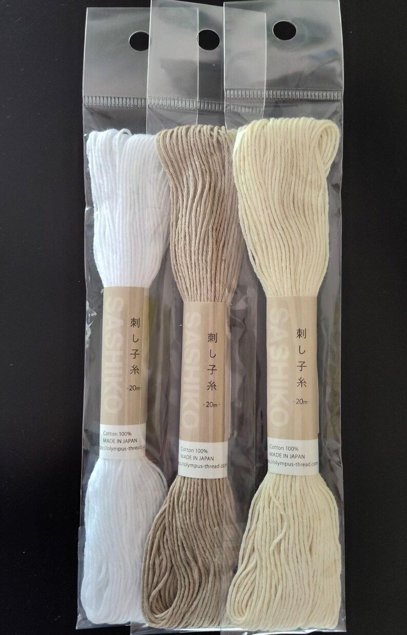 Puede incluir: Tres bobinas de hilo Sashiko en un paquete de pl&aacute;stico transparente. Los colores del hilo son blanco, marr&oacute;n y crema. Cada bobina tiene una etiqueta de papel con texto japon&eacute;s y el nombre de la marca. El hilo es 100% algod&oacute;n y est&aacute; hecho en Jap&oacute;n.