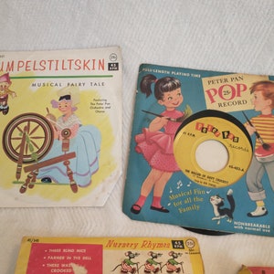 May include: A collection of vintage children's records featuring fairy tales and nursery rhymes. The records are in colourful cardboard sleeves with illustrations of the stories. The sleeves are labelled with the titles "Rumpelstiltskin", "Peter Pan Pop Record", "Nursery Rhymes", and "Children's Songs".