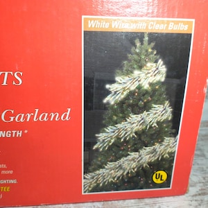May include: A red box with text that reads "LIGHTS Vine Lighting Garland". The box features an image of a Christmas tree decorated with white vine garland and clear bulbs. The text "White Wire with Clear Bulbs" is also visible.