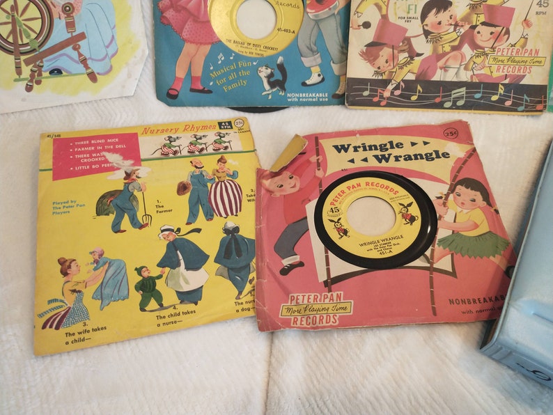 May include: A collection of vintage children's records with colourful covers featuring illustrations of nursery rhymes and a cartoon character. The records are labelled "Peter Pan Records" and "More Playing Time Records".