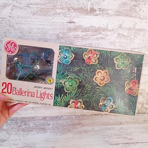 May include: Vintage box of 20 "Ballerina Lights" Christmas lights. The box features a GE logo and a picture of flower-shaped lights. The lights are green and the box has a clear plastic window showing the lights inside.