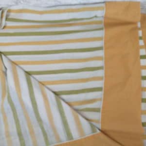 May include: A striped throw blanket with a white, yellow, and green striped pattern. The blanket has a solid yellow border.