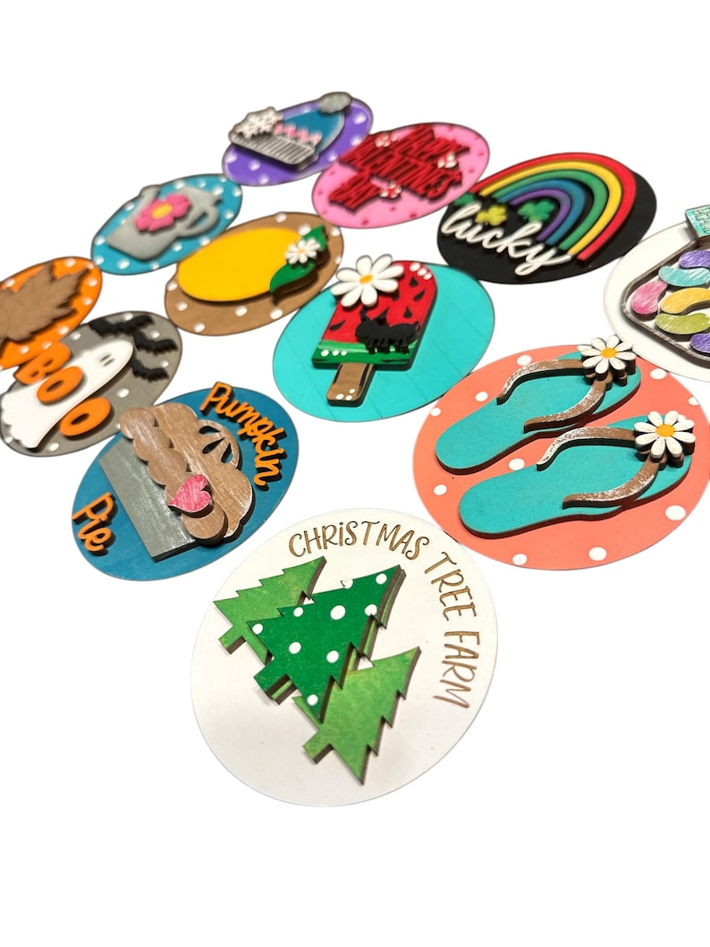 May include: A set of 12 wooden ornaments with various designs, including a pumpkin pie, a Christmas tree, a rainbow, and a popsicle. The ornaments are painted in bright colors and have a polka dot background.