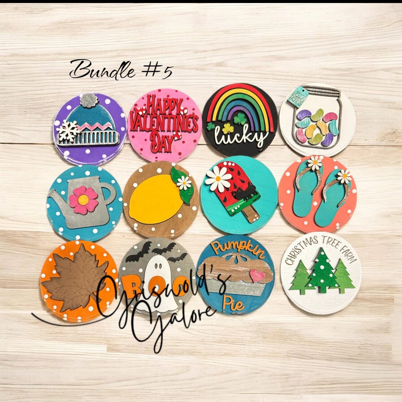 May include: A bundle of 12 round wooden signs with various holiday and seasonal themes. The signs feature painted designs including a snowman, a lemon, a ghost, a pumpkin pie, a Christmas tree, a rainbow, a watermelon popsicle, a jar of jelly beans, a watering can, flip flops, and a fall leaf. The signs are all painted in bright colors and have a rustic, handmade look.