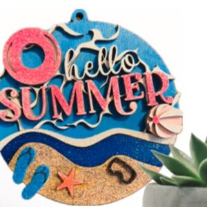 May include: Round wooden sign with the text "hello summer" in pink and blue lettering. The sign features a beach scene with a blue ocean, sand, flip flops, a starfish, and a beach ball.