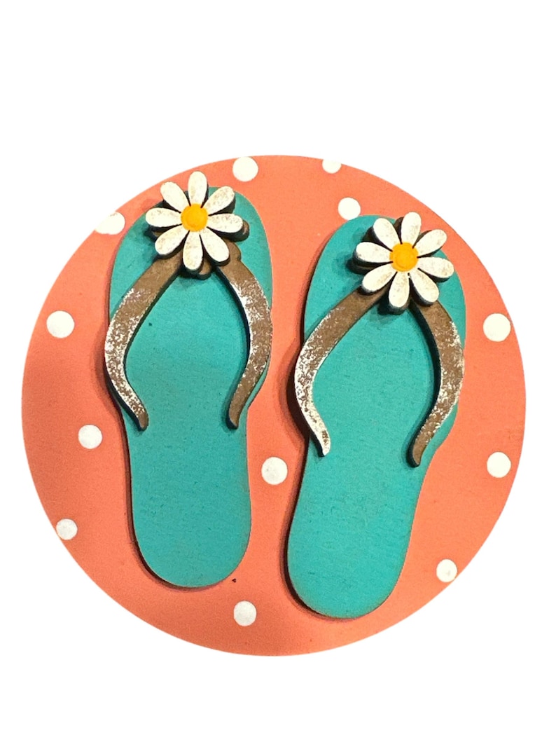 May include: A pair of turquoise blue flip flops with white daisy flowers on the straps, on a coral pink background with white polka dots.