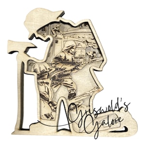 May include: A wooden layered art piece depicting firefighters battling a blaze. The artwork is in the shape of a firefighter's silhouette, with an axe on the side. The text "Griswold's Galore" is written in cursive at the bottom.