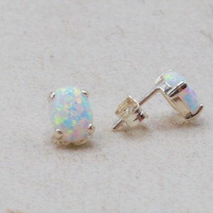 Puede incluir: Un par de pendientes de plata con piedras de &oacute;palo blanco ovaladas.