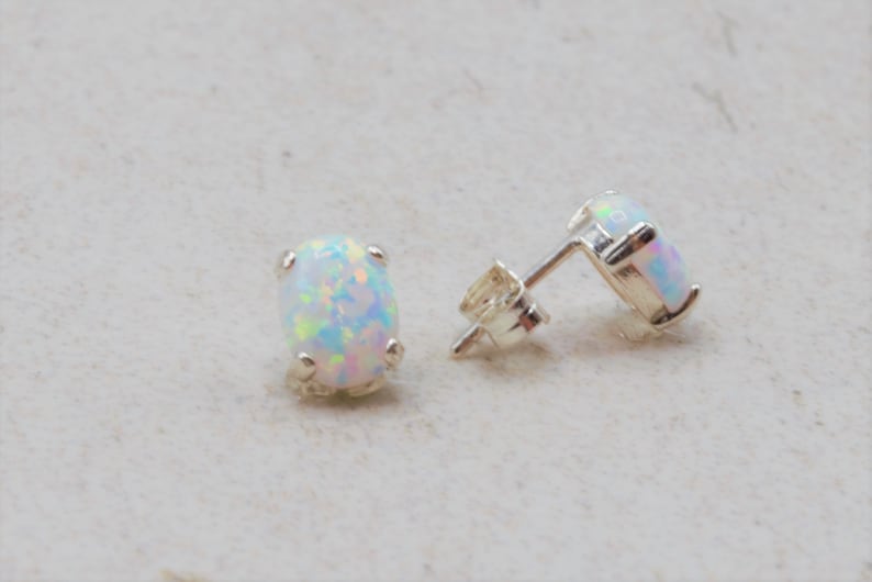 Puede incluir: Un par de pendientes de plata con piedras de &oacute;palo blanco ovaladas.