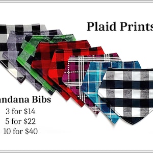 May include: Seven plaid bandana bibs in various colors, including black, white, red, green, blue, and purple. The bibs are arranged in a row, with the black and white bib at the bottom. The text "Bandana Bibs" and "Plaid Prints" is visible in the image. The text "3 for $14, 5 for $22, 10 for $40" is also visible.
