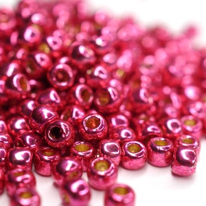 May include: A pile of shiny pink beads, perfect for jewelry making or crafting projects.