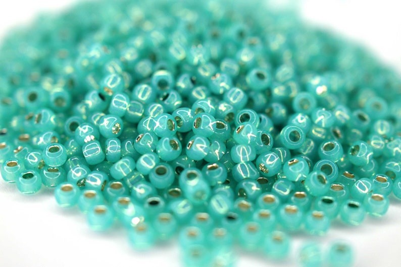 380 EUR/kg 10g Toho Seed Beads 11/0 Silver-Lined Milky Dark Peridot Bild 1