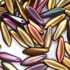 May include: A collection of iridescent glass beads in shades of gold, copper, green, and purple. The beads are long and narrow, with a slightly pointed end.