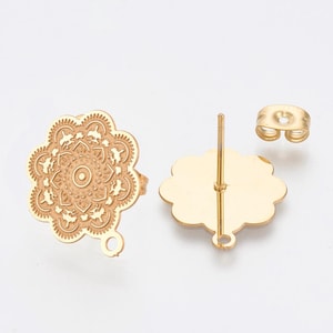 May include: Gold-coloured metal earring components. The earrings feature a floral design with a central circle and detailed patterns. One earring post is visible, along with a butterfly earring back.