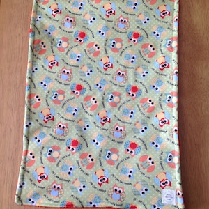 May include: A green fabric with a repeating pattern of owls. The owls are multi-colored and have the text "Who loves you? I do!" and "You're such a hoooot!" on them.