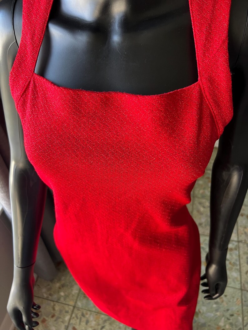 May include: A red sleeveless dress with a square neckline and a sparkly texture.